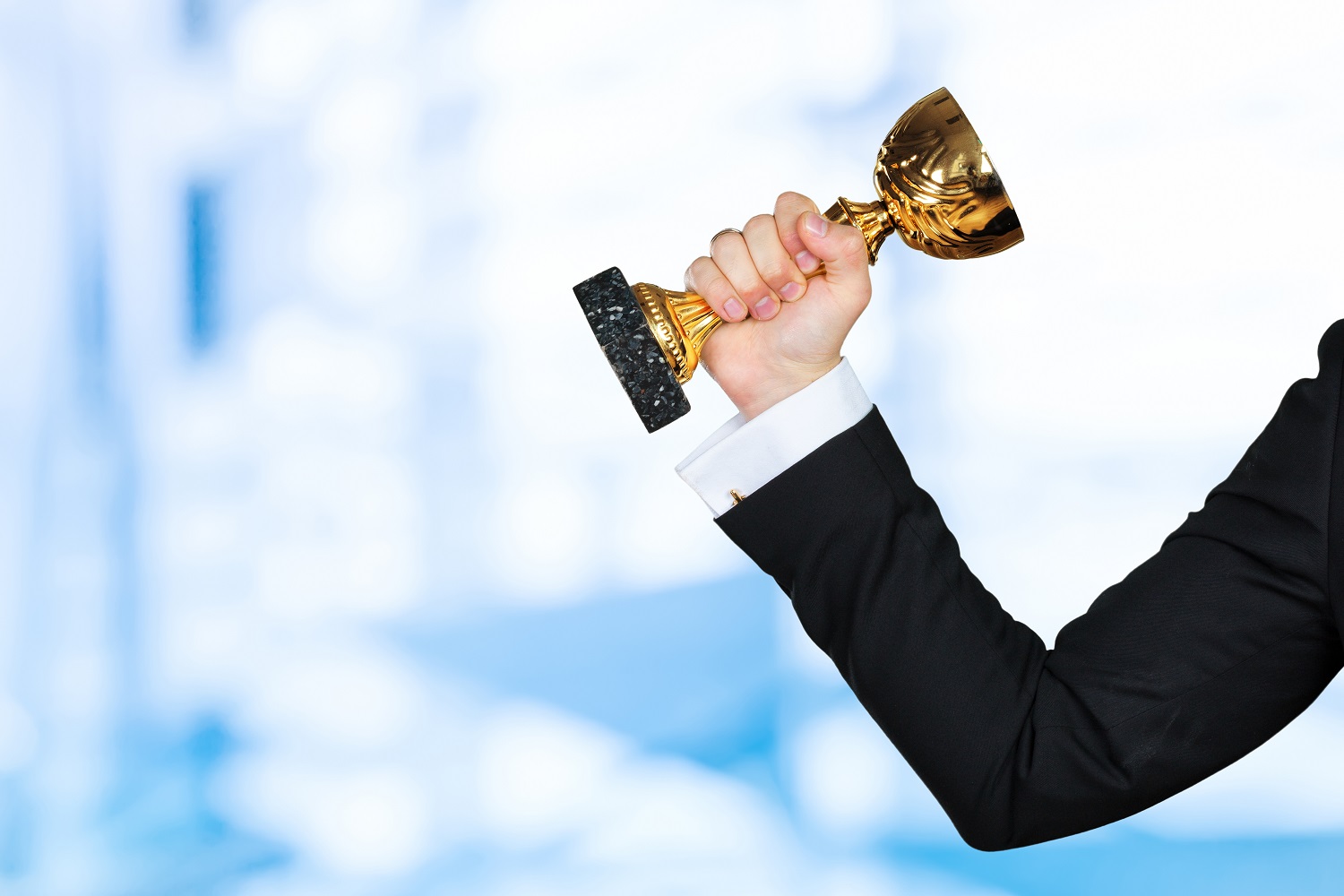 Businessman holding golden cup trophy